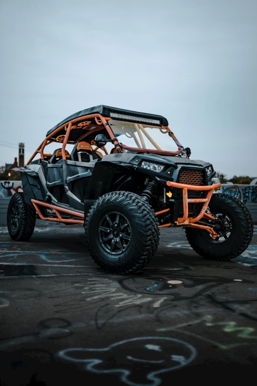 a can - am outlander can be seen driving around in the wet parking lot