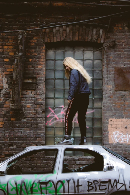 woman walking in graffiti - covered alleyway while on her skateboard