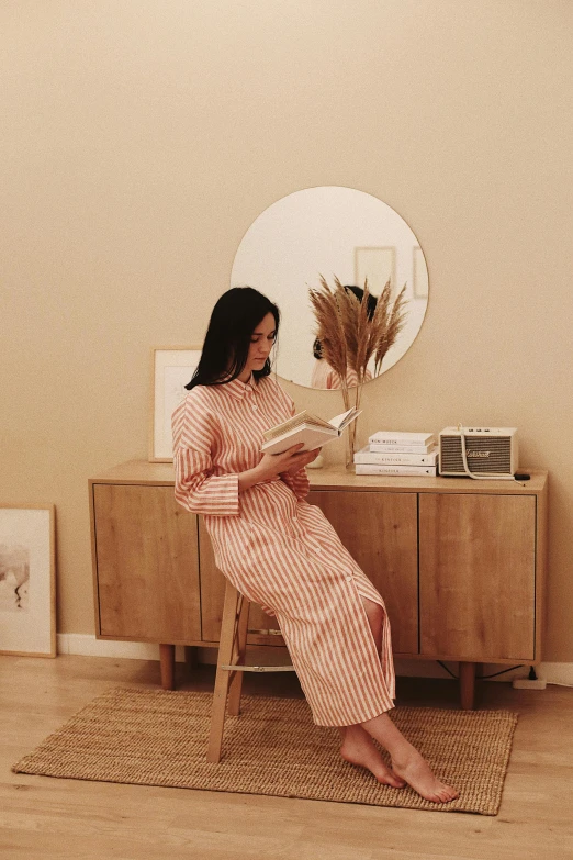 a woman sitting on top of a chair holding a piece of paper