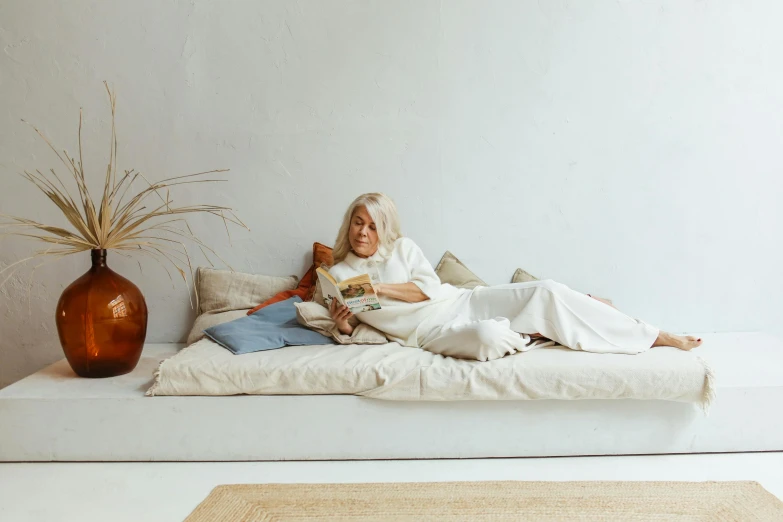 a woman in a white robe laying on a couch