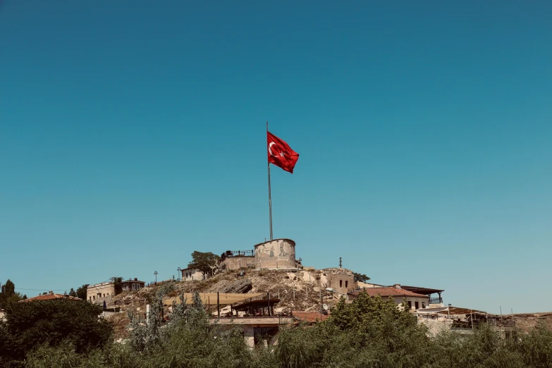 there is a large flag flying on top of a hill