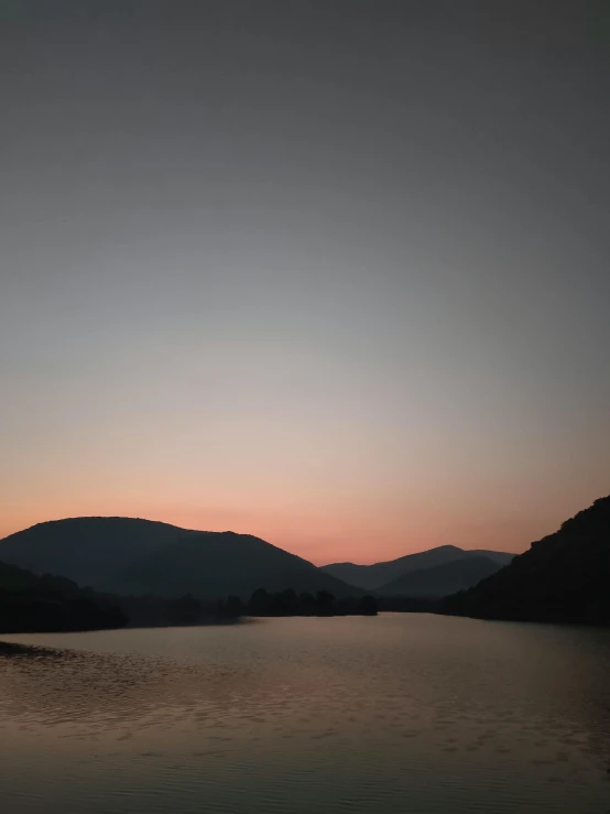 the sky at sunset with mountains in the background