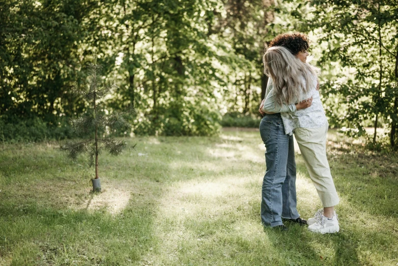 a woman holding onto a man in a field