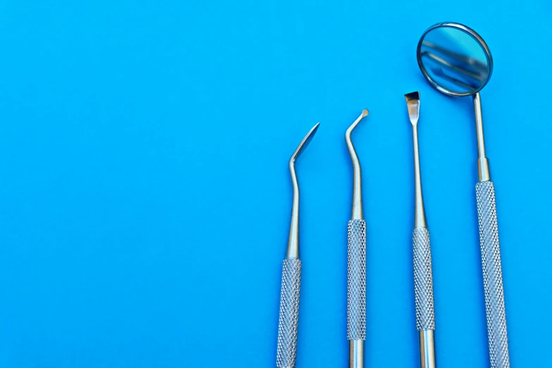three different types of surgical tools are sitting on a blue surface