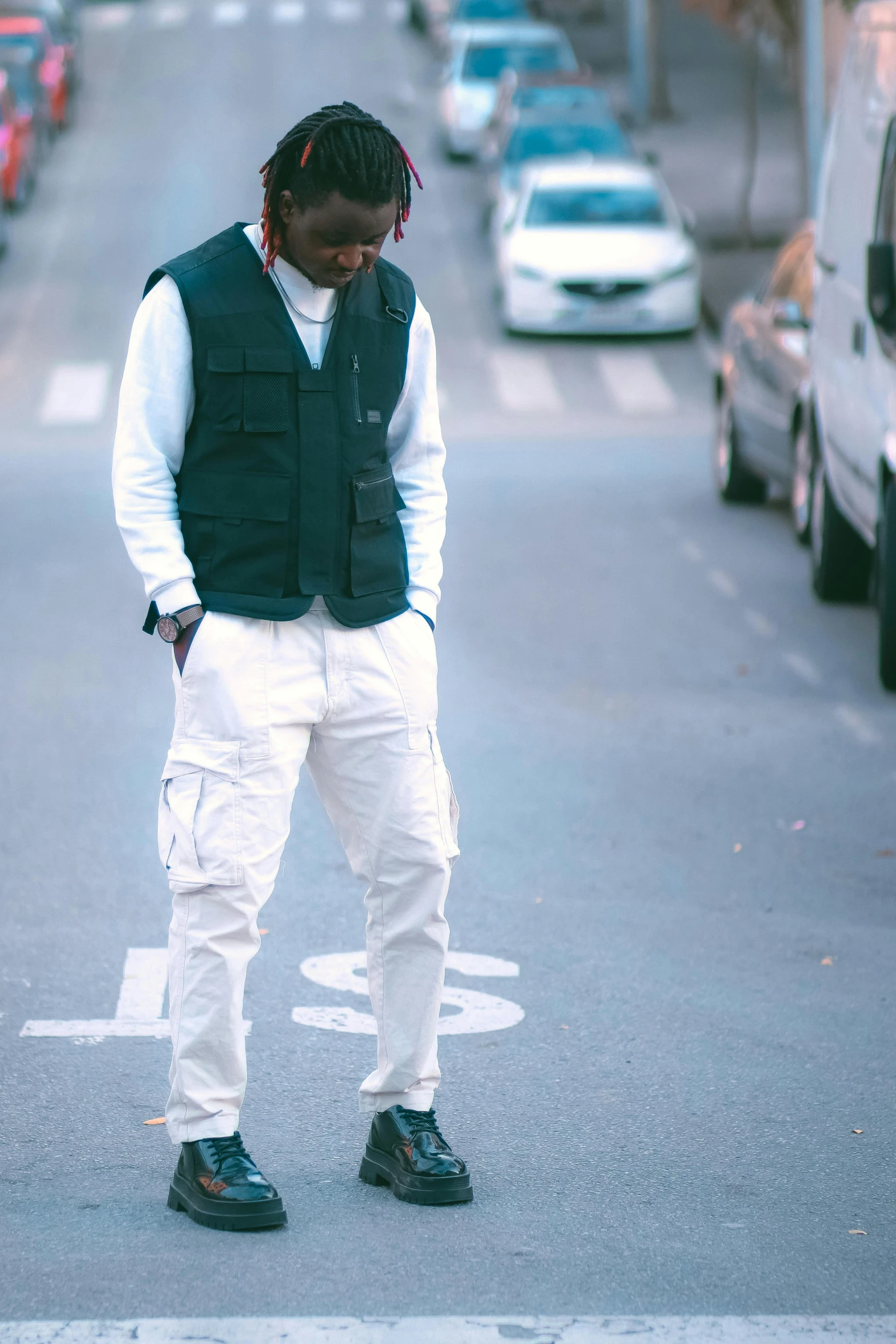 a man standing in the street next to a bunch of cars