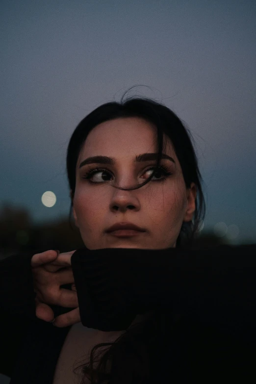 a woman with makeup looks directly at the camera