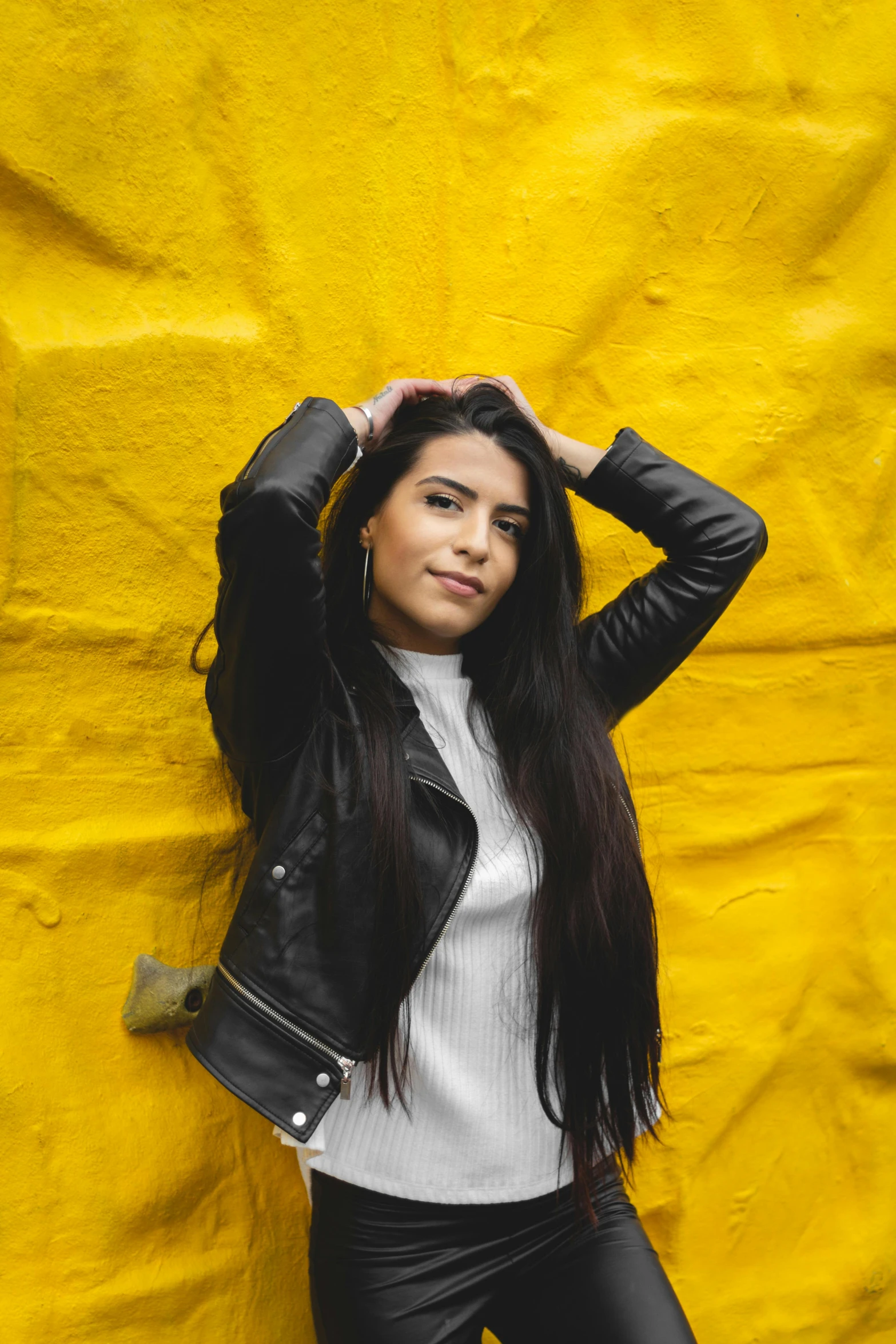 woman with black hair in front of yellow fabric