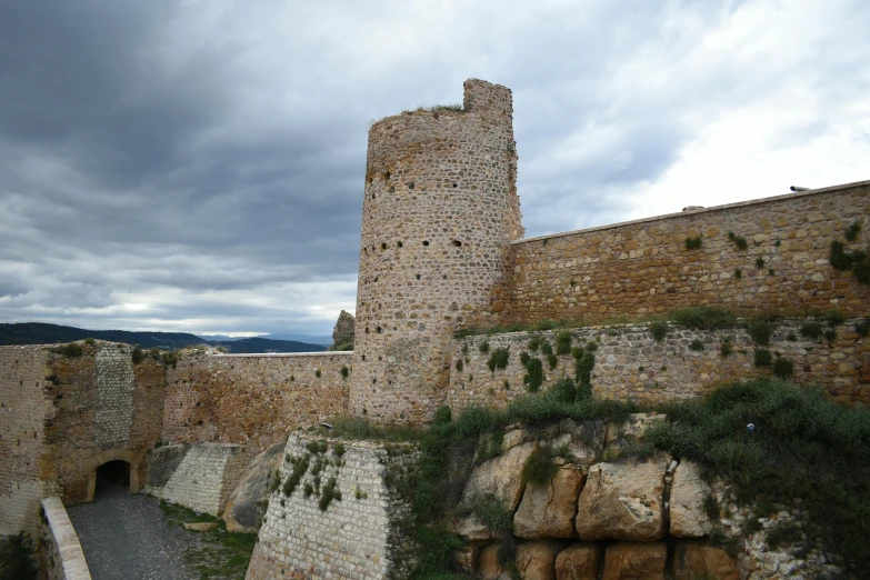 a large stone castle sitting on top of a lush green hillside