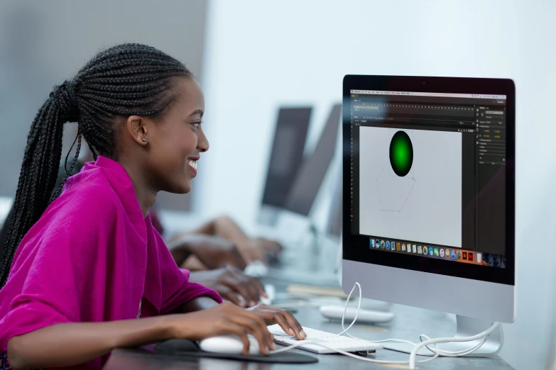 a woman sitting in front of a computer monitor