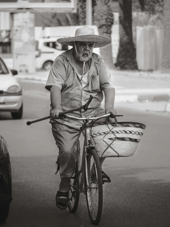 the old man is riding his bike while carrying an empty basket