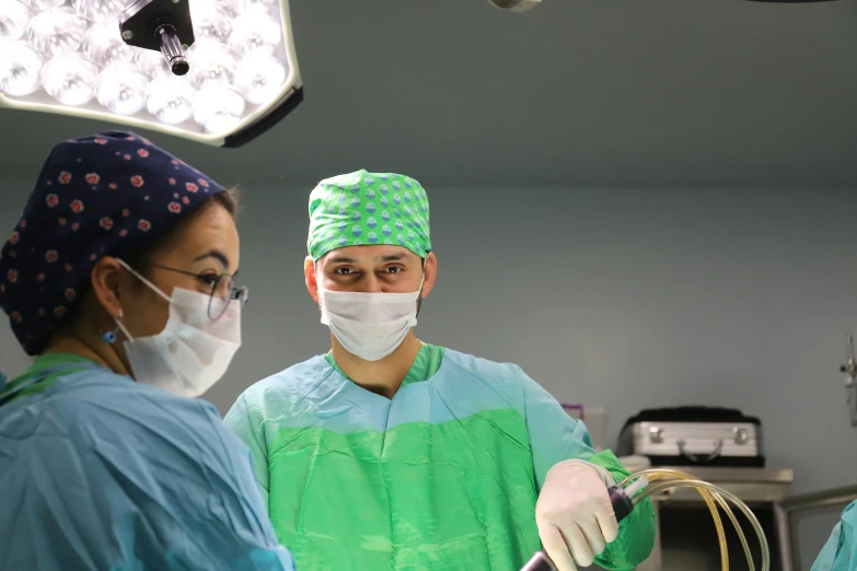 two doctors stand in front of a surgical light