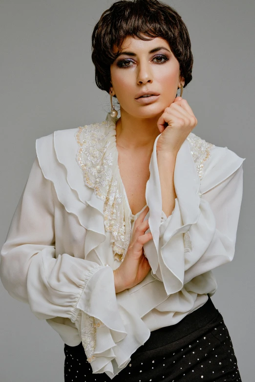 an older woman poses in white top with polka dots