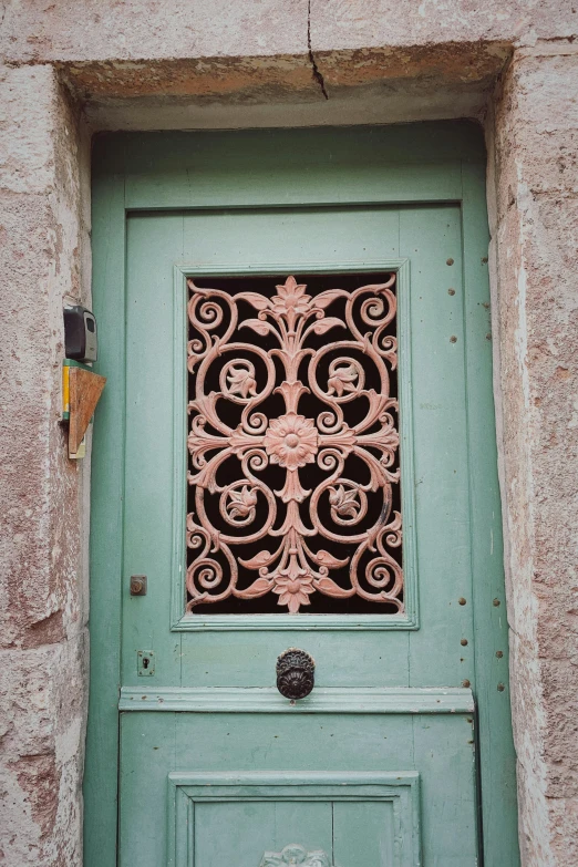 a green door with an ornamental design in the middle of it