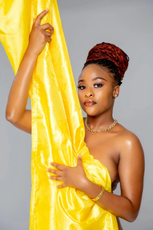 an african woman is posing with her yellow dress