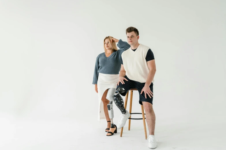 two people pose on chairs in the studio
