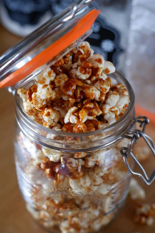 a jar with popcorn on a wooden table