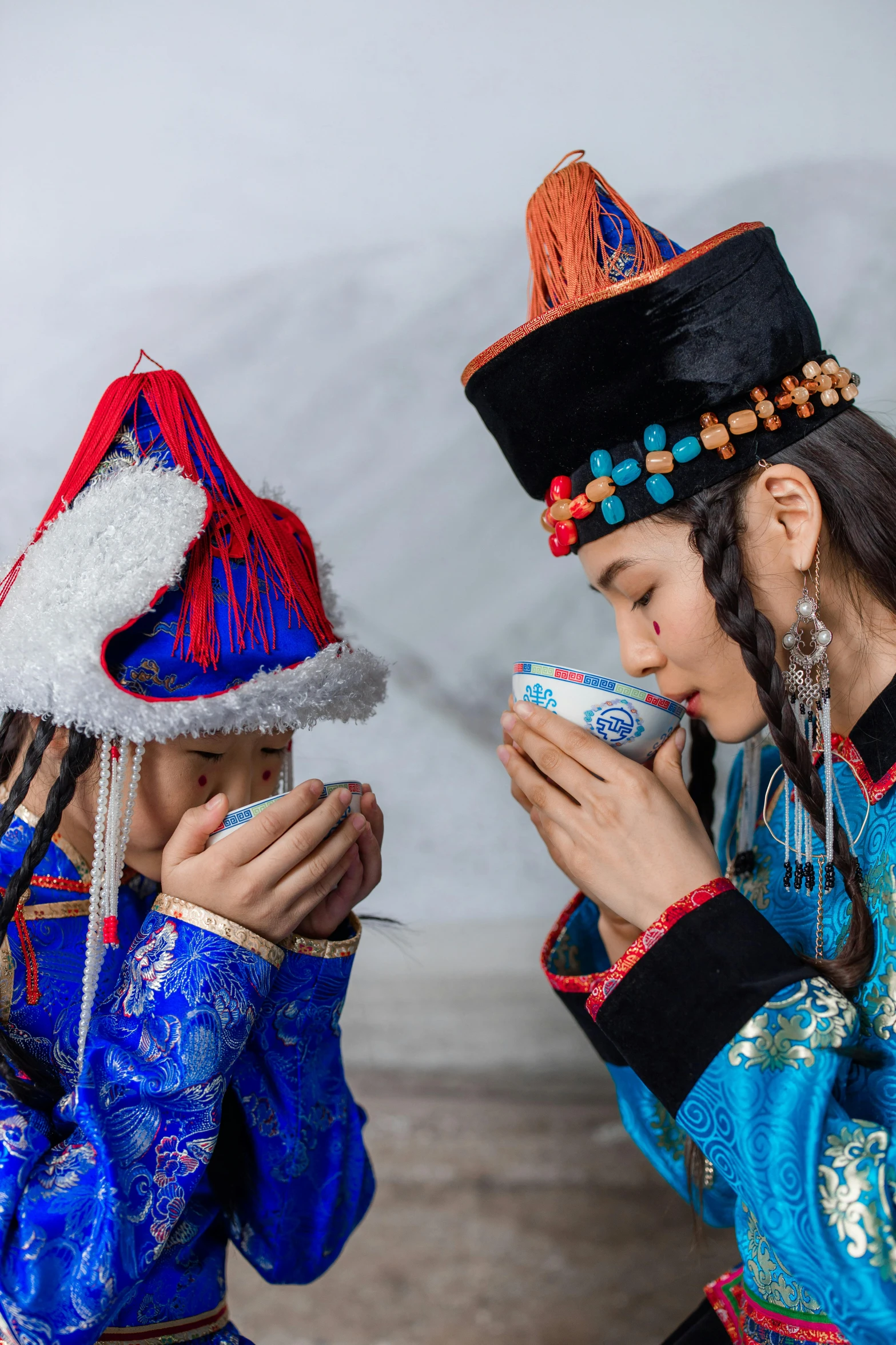 two girls wearing native garb sitting next to each other