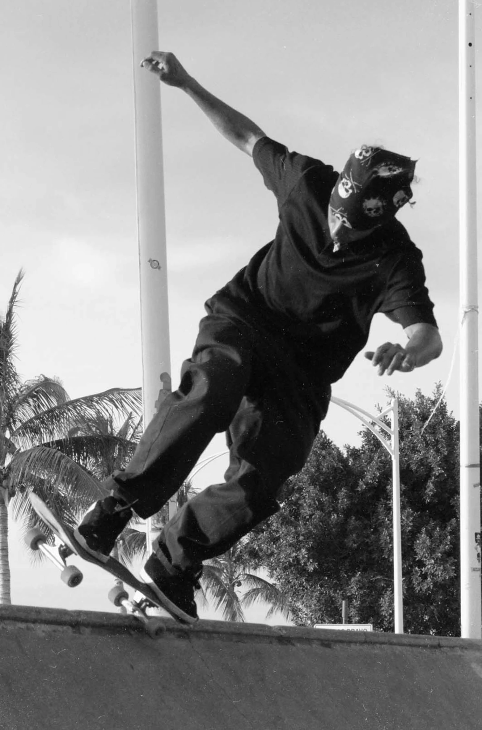 black and white pograph of skateboarder performing trick on wall