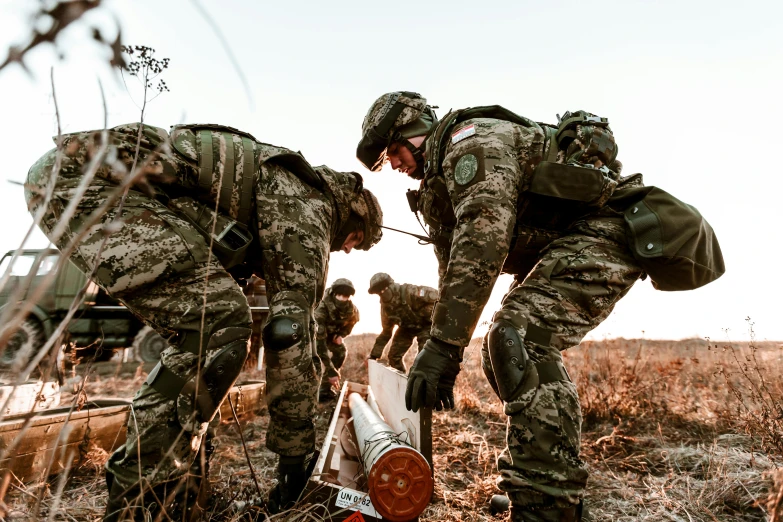 a group of soldiers are inspecting items in the woods