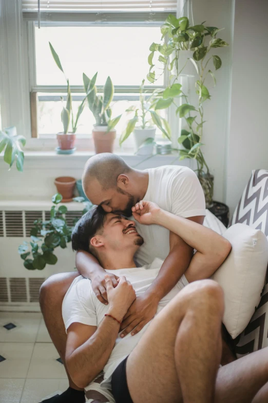 two people cuddling together in a room with a window