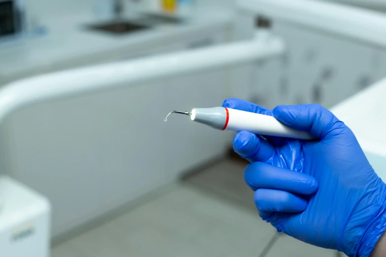 a dentist holds a tiny plastic white object