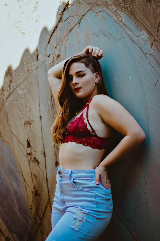 an attractive woman leaning up against a rock