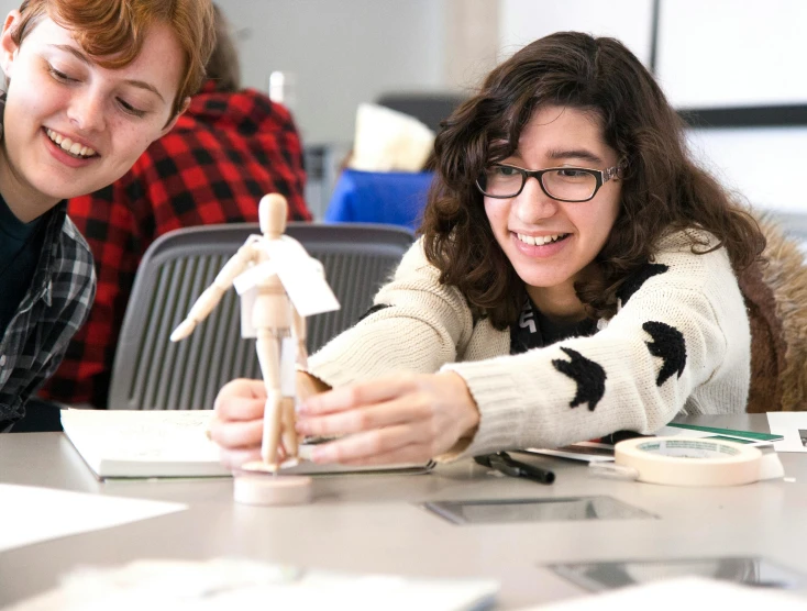 two people looking at model figurines on the table