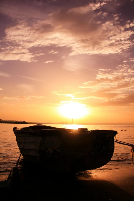 a boat sitting on top of a beach next to the ocean