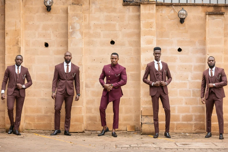 a group of men in formal attire standing next to a wall