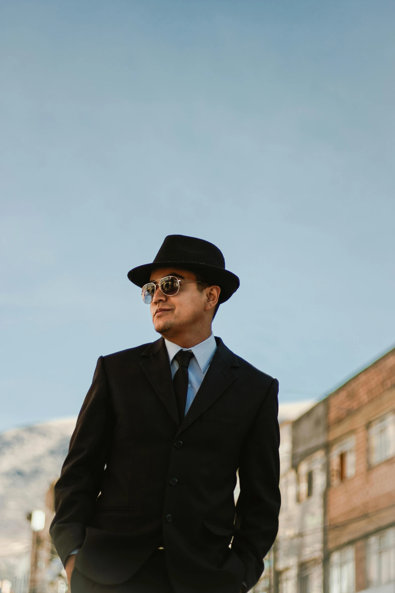 a man in a suit and hat and sunglasses