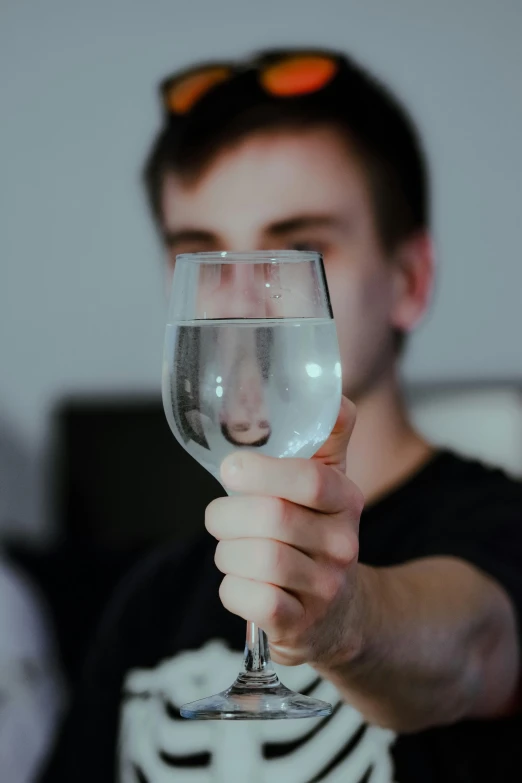 a man holding a wine glass up to his face