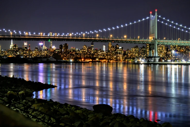 the skyline is lit up at night time and has bright lights in the windows