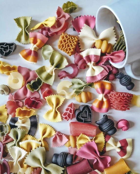 assorted different colored pasta pieces and a bowl of sauce