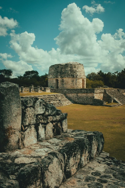 some very old rocks and a large building in the background