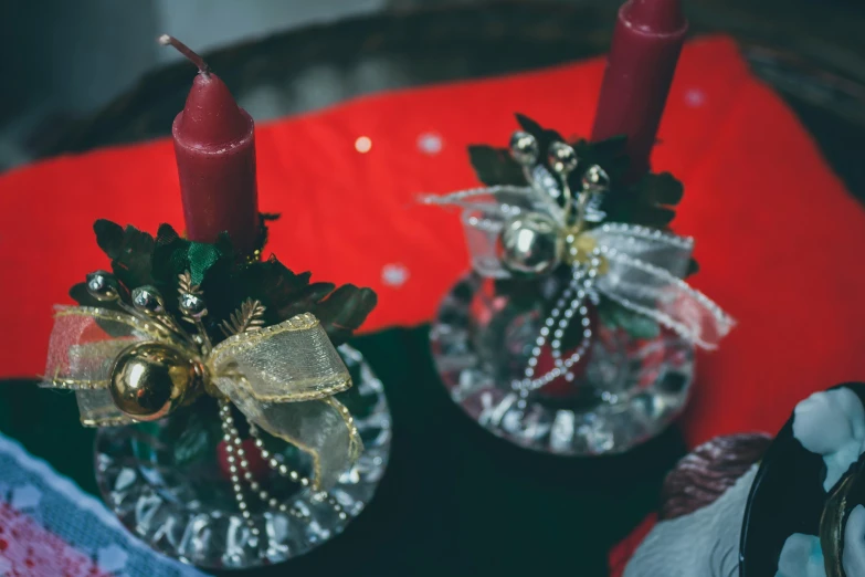 two candles are set on small glass dishes