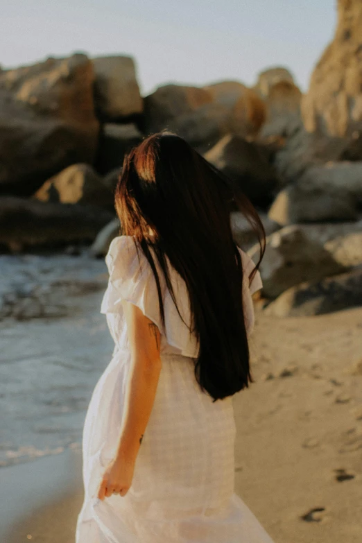 a woman is walking alone on the beach