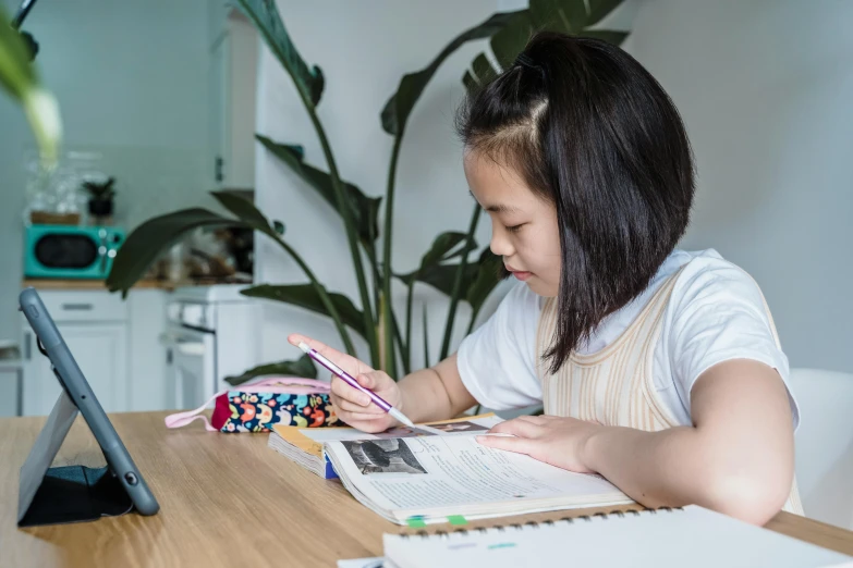 a little girl who is playing with a tablet