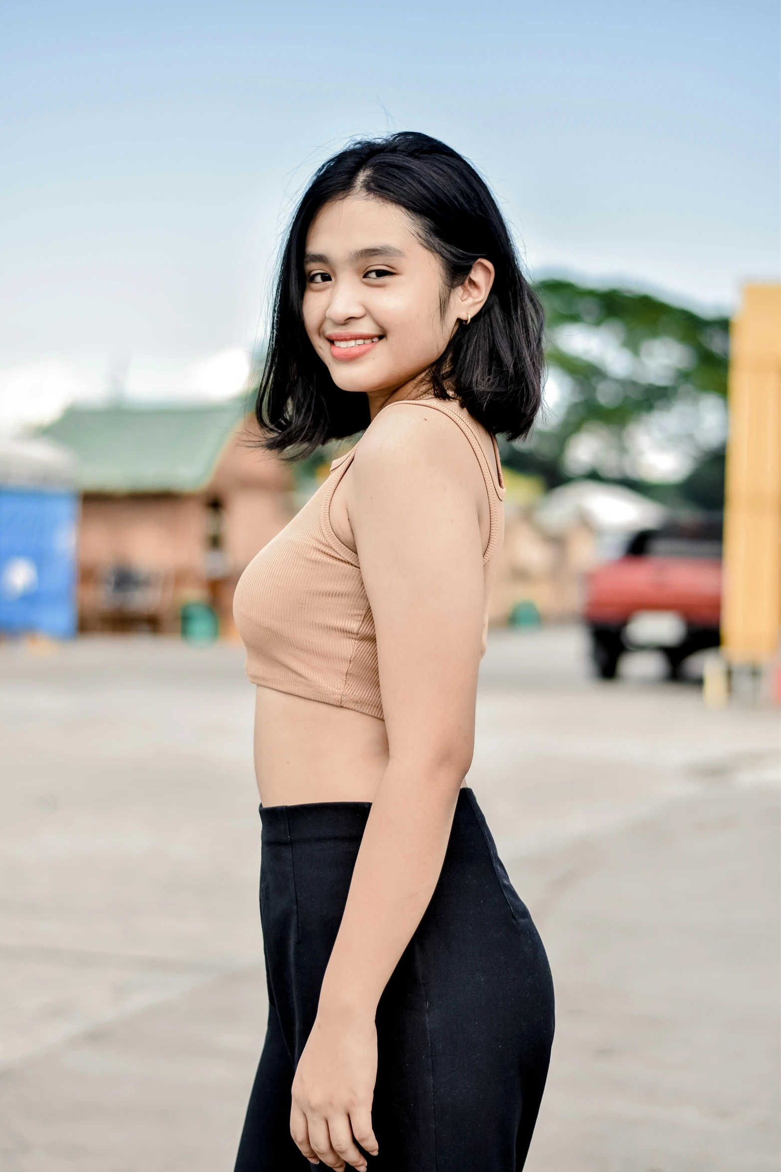 a young lady in black pants standing in front of a building