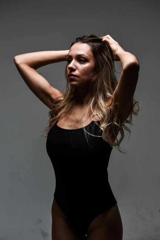 a woman posing in a black bathing suit