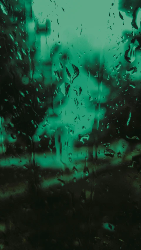 a window with a blurry background with water drops on it