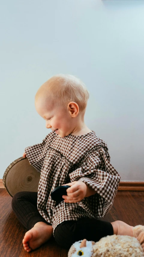 a little boy that is sitting in the floor