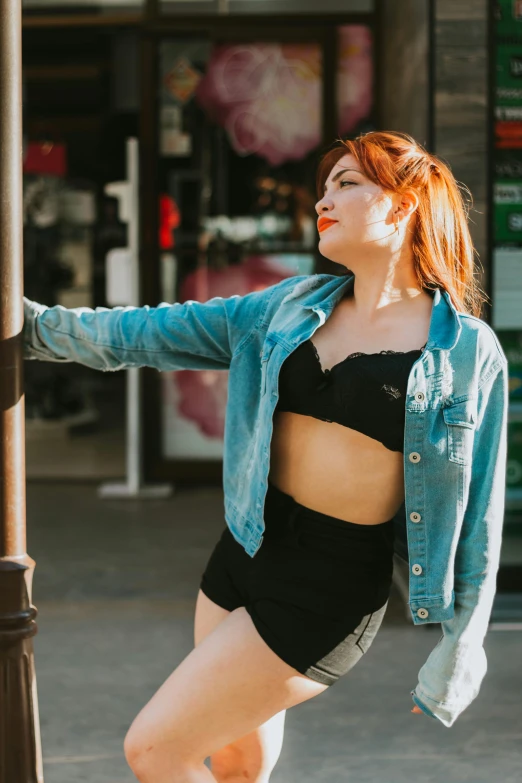 a woman leaning against a pole with her  on