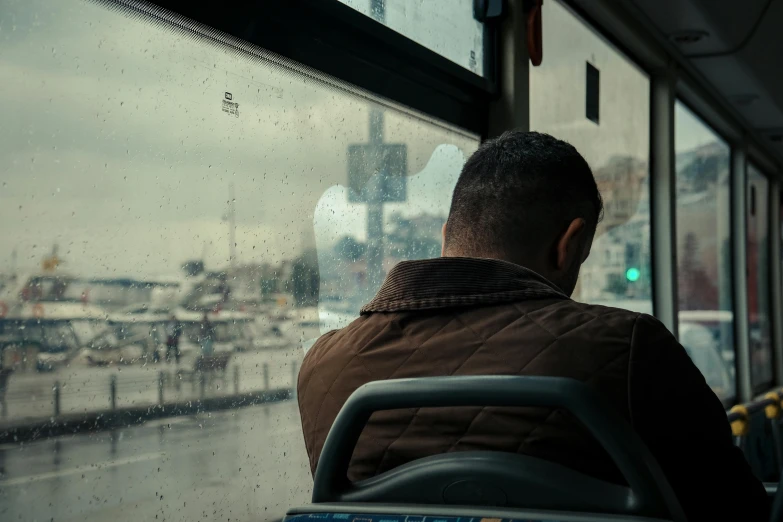 a man looking out the window of a bus at the street outside