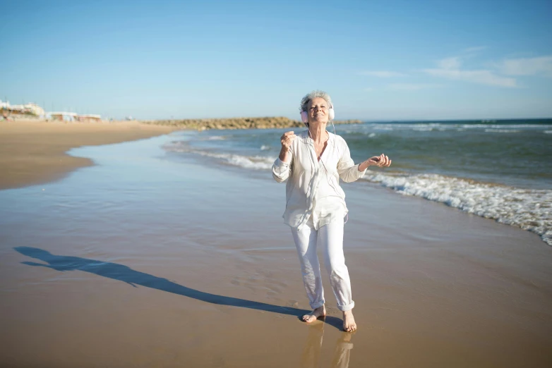 a woman standing on a beach next to the ocean