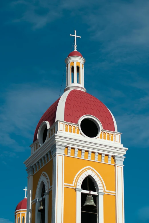 a large yellow building has a red roof