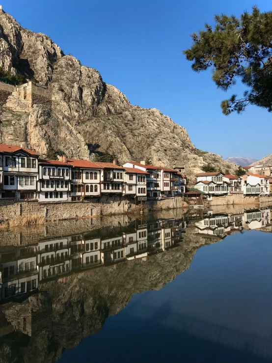 a body of water near a city next to a mountain