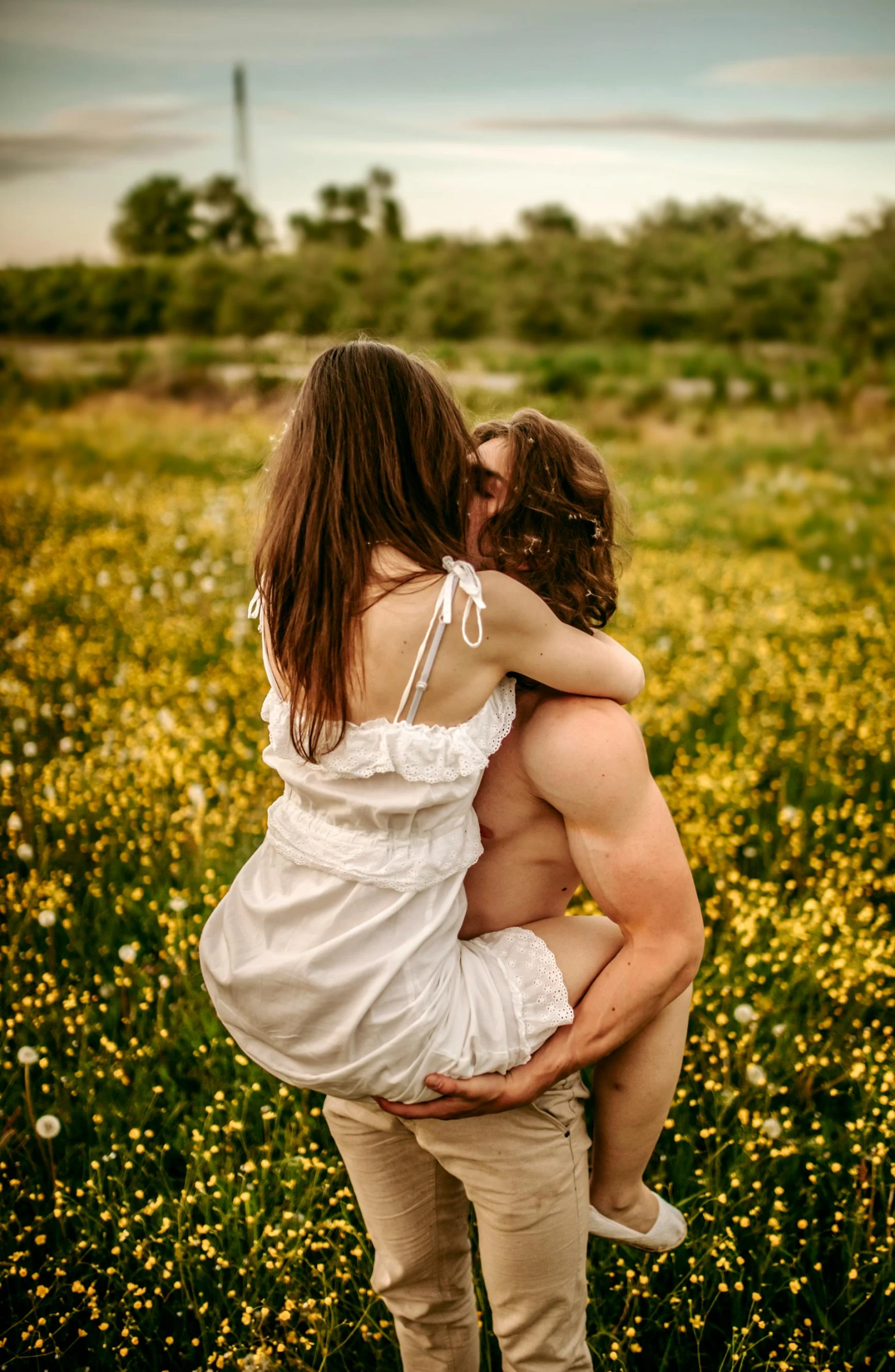 a couple of girls hug in a field of flowers