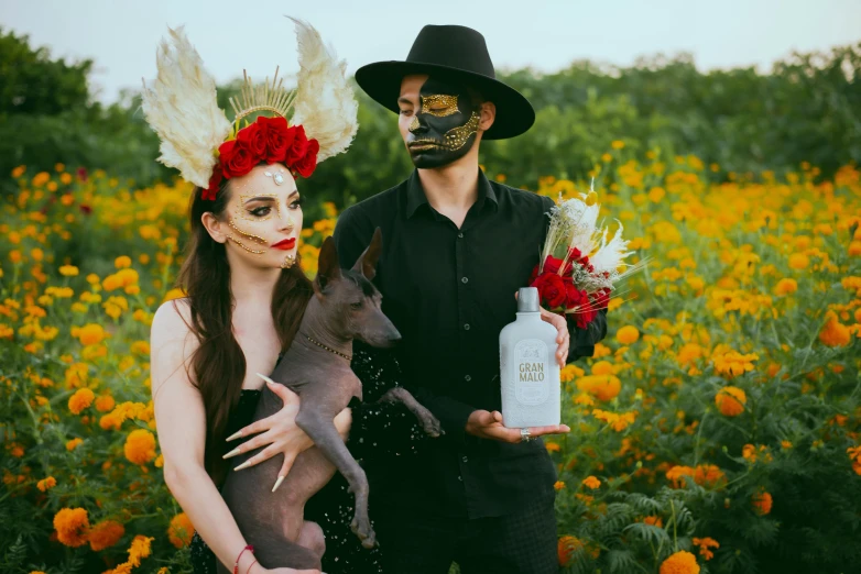 man in a black mask and devil makeup holding a kitten