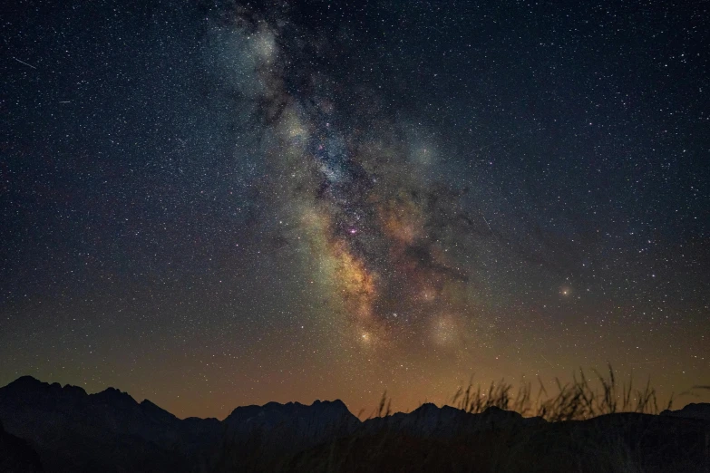 a very large star filled sky with stars above the mountains