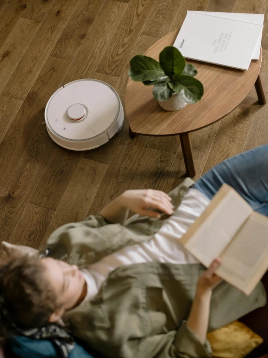 the woman is reading her book on the floor